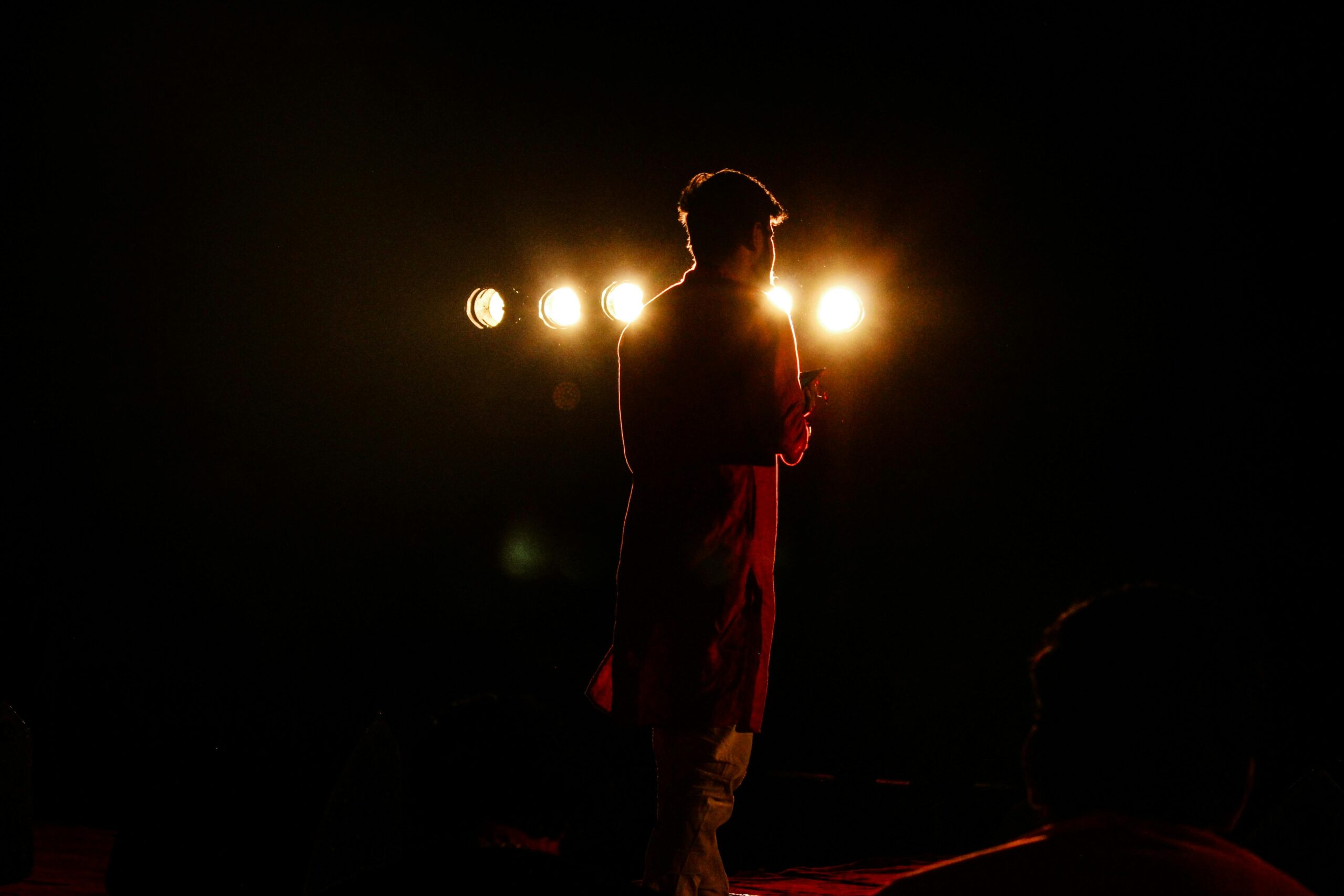 Captivating silhouette of a performer on stage with dramatic lighting and backlight.